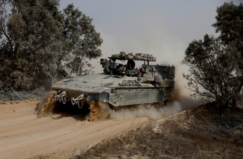  Israeli soldiers work on an APC near the Gaza border, in Israel, May 27, 2024 (credit: AMIR COHEN/REUTERS)