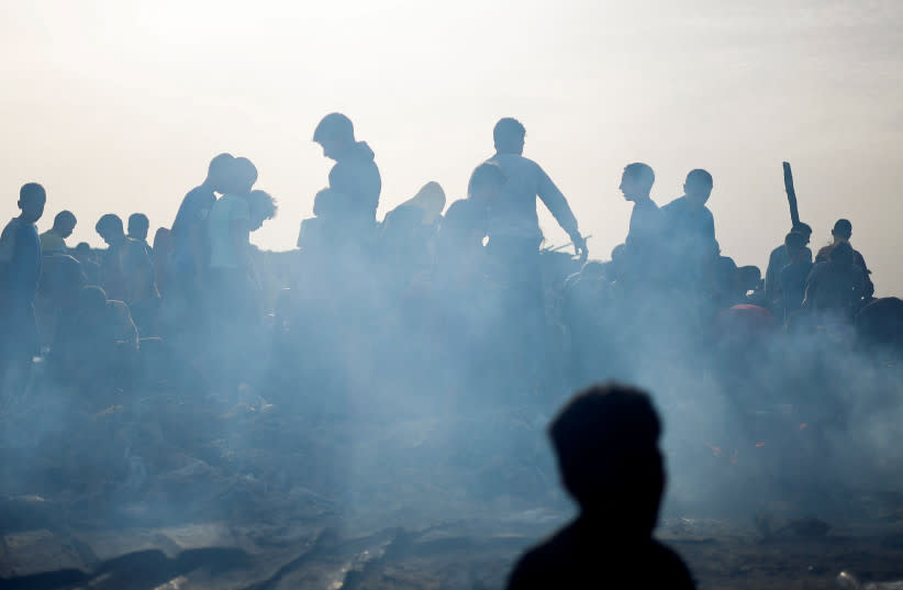  Palestinos buscan comida entre los escombros quemados tras un ataque israelí contra una zona designada para desplazados, en Rafah, en el sur de la Franja de Gaza, 27 de mayo de 2024.  (credit: MOHAMMED SALEM/REUTERS)