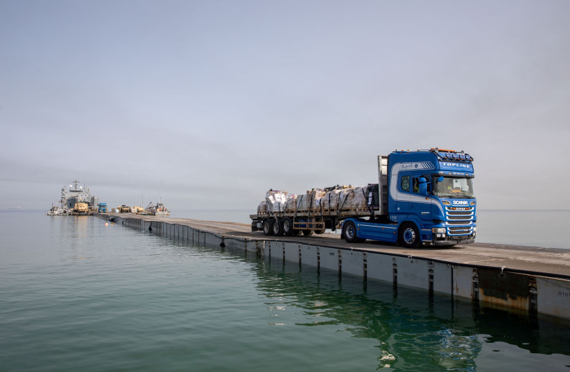  A truck carries humanitarian aid across Trident Pier, a temporary pier to deliver aid, off the Gaza Strip, amid the ongoing conflict between Israel and the Palestinian Islamist group Hamas, near the Gaza coast, May 19, 2024.  (credit: VIA REUTERS)