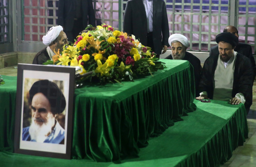 Iranian then-president-elect Hassan Rouhani (2nd R) pays his respects to the grave of the founder of the Islamic Republic Ayatollah Ruhollah Khomeini at his mausoleum in Tehran June 16, 2013.