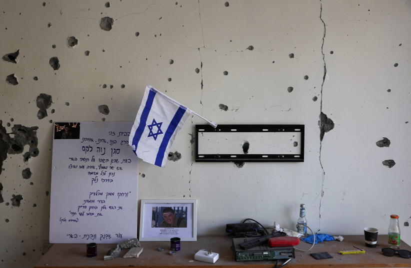  A view of an Israeli flag and other belongings inside a burnt house that has been abandoned for two months after the deadly October 7 attack by gunmen from Palestinian militant group Hamas from the Gaza Strip, in Kibbutz Beeri, southern Israel, December 7, 2023.  (credit: ATHIT PERAWONGMETHA / REUTERS)