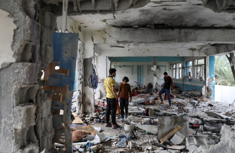  Palestinos inspeccionan el lugar de un ataque israelí contra una escuela de la UNRWA que acoge a personas desplazadas, en medio del conflicto entre Israel y Hamás, en el campo de refugiados de Nuseirat, en el centro de la Franja de Gaza, el 6 de junio de 2024.  (credit: REUTERS/Abed Khaled)