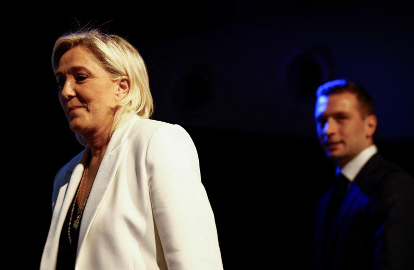 Jordan Bardella, President of the French far-right National Rally (Rassemblement National - RN) party and head of the RN list for the European elections, and Marine Le Pen, President of the French far-right National Rally party parliamentary group, take the stage to address party members after the p (credit: Sarah Meyssonnier/Reuters)