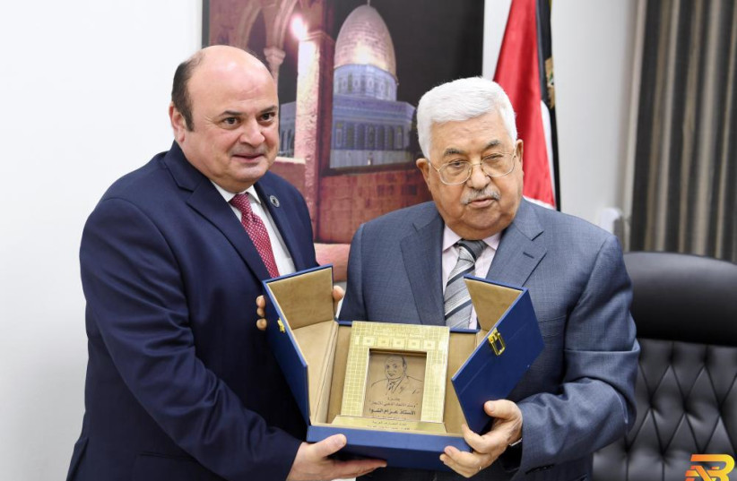  Shawwa and Palestinian Authority President Mahmoud Abbas pose with the Golden Union Medal of Achievement from the Union of Arab Banks, at Abbas' office in Ramallah, May 18, 2018.  (credit: Courtesy)
