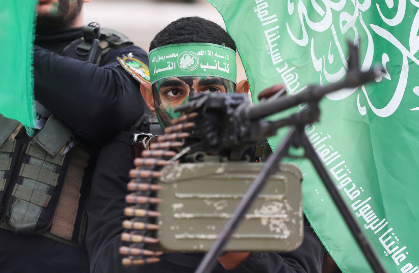  Palestinian Hamas terrorists take part in a rally during the 35th anniversary of Hamas founding, in Khan Younis in the southern Gaza Strip, December 14, 2022.  (credit: REUTERS/IBRAHEEM ABU MUSTAFA)