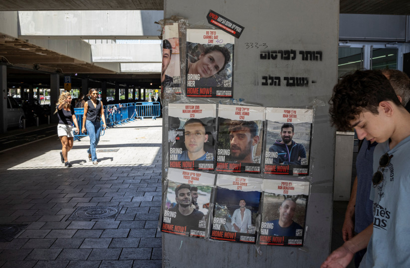 Israelis walk past posters in support of hostages, in Tel Aviv, Israel, June 16, 2024 (credit: REUTERS/MARKO DJURICA)