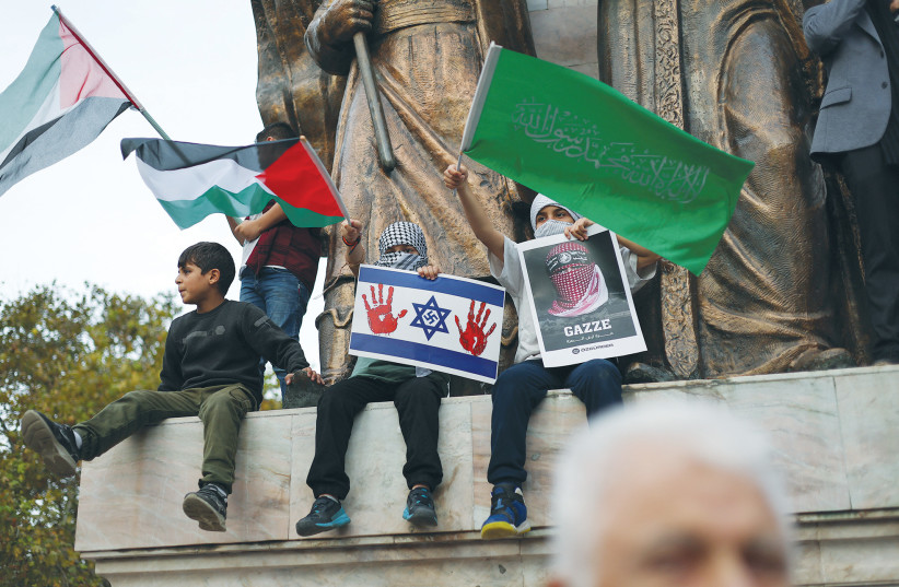  A CHILD holds a sign depicting the Israeli flag with a swastika and bloody hand prints, at a pro-Palestinian demonstration, in Istanbul, during a visit by US Secretary of State Antony Blinken to Turkey, in November. (credit: MURAD SEZER/REUTERS)