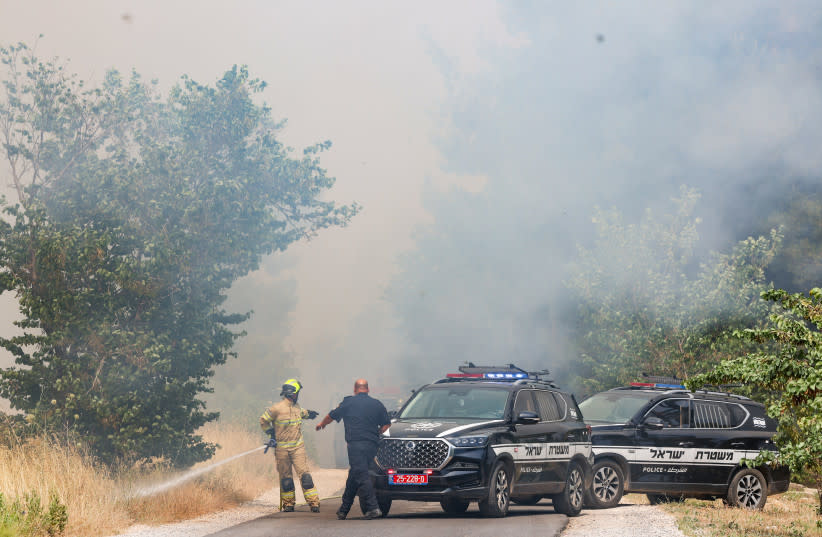  Agentes de policía en el lugar de un incendio provocado por misiles lanzados desde el Líbano, en el bosque de Biriya, en el norte de Israel, el 13 de junio de 2024 (credit: David Cohen/Flash90)