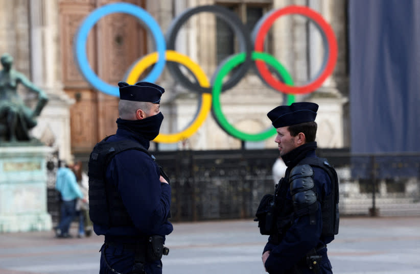 Agentes de la policía francesa montan guardia, cerca de los anillos olímpicos que se exhiben con motivo de los Juegos de Verano de París 2024. 21 de marzo de 2023.