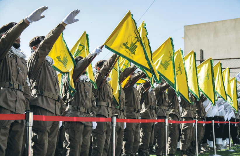 OPERATIVOS DE HEZBOLLAH saludan durante el funeral de compañeros muertos en un ataque israelí, en Shehabiya, sur del Líbano, el 17 de abril.