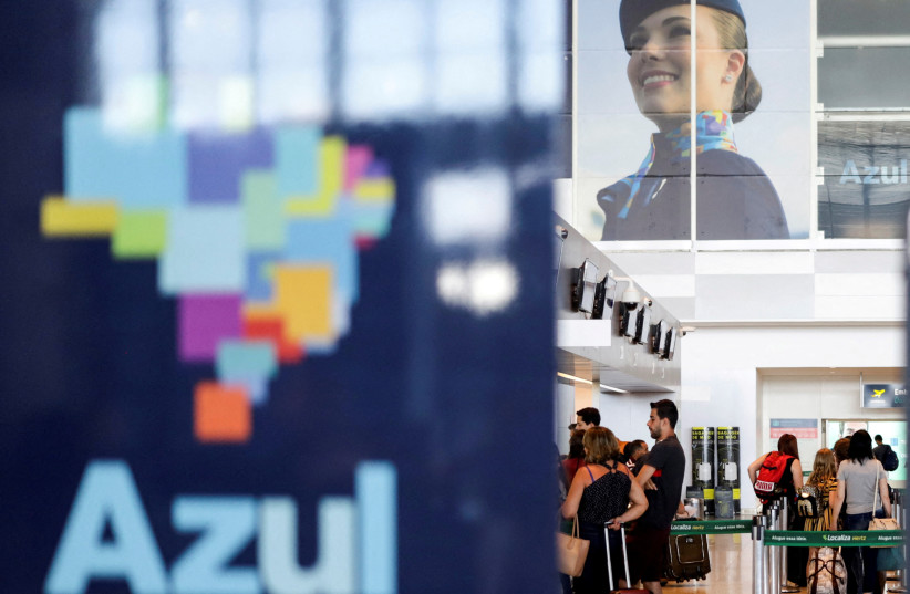 Passengers stand near a Brazilian airline Azul signage at Viracopos International Airport, in Campinas, Sao Paulo State, Brazil, March 16, 2 (credit: REUTERS/RAHEL PATRASSO)