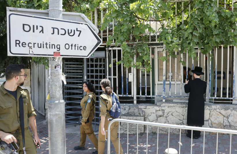  An ultra-Orthodox man is seen onlooking an IDF recruiting office in Jerusalem, June 25, 2024 (credit: MARC ISRAEL SELLEM/THE JERUSALEM POST)