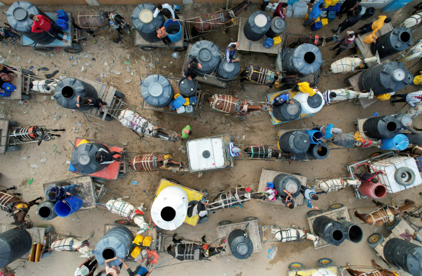 Palestinians with animal-drawn carts collect water from a water desalination plant, amid water shortages, as the conflict between Israel and the Palestinian Islamist group Hamas continues, in central Gaza Strip October 27, 2023.