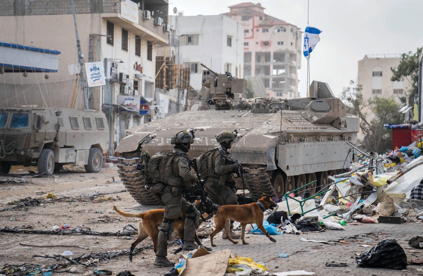  Troops and dogs of the Oketz Canine Unit operate in the Gaza Strip, in an IDF handout image published November 26, 2023. (credit: IDF)