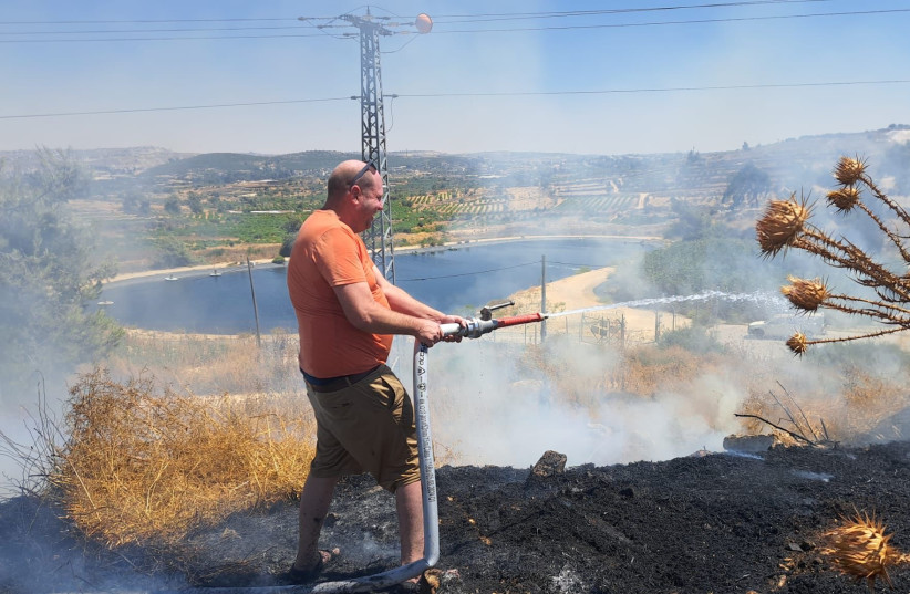  Gush Etzion Regional Council head Yaron Rosenthal fighting a fire that broke out near Kfar Etzion, June 28, 2024. (credit: Courtesy)