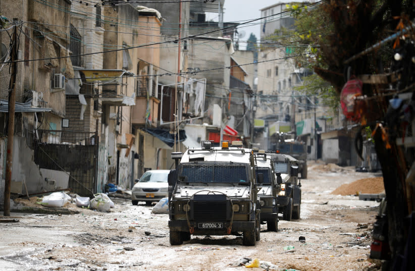  Vehículos militares circulan por una calle durante una incursión israelí en Tulkarm, en Cisjordania, el 18 de febrero de 2024.  (credit: RANEEN SAWAFTA/REUTERS)
