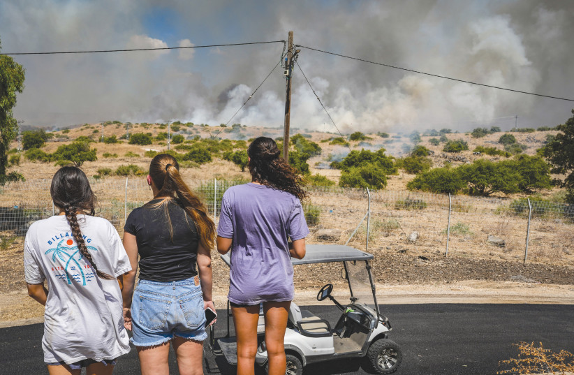 PEOPLE LOOK ON as smoke rises from a fire that broke out near Kibbutz Shamir in the Upper Galilee, as a result of a rocket attack from Lebanon, last week. The writer asks: What about securing the ability of our citizens to return to their homes in the North?
