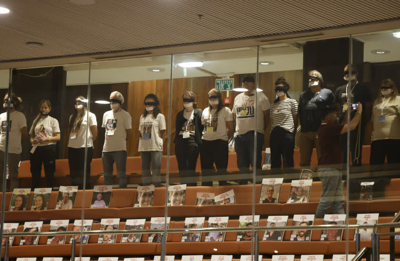Familiares de rehenes sentados en la Knesset con fotos de sus parientes en sillas vacías.