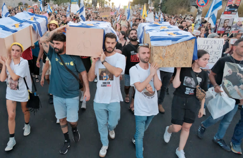 Decenas de miles de manifestantes marchan detrás de los manifestantes que portan ataúdes en representación de los 6 rehenes asesinados a finales de la semana pasada, en dirección a la calle Begin de Tel Aviv
