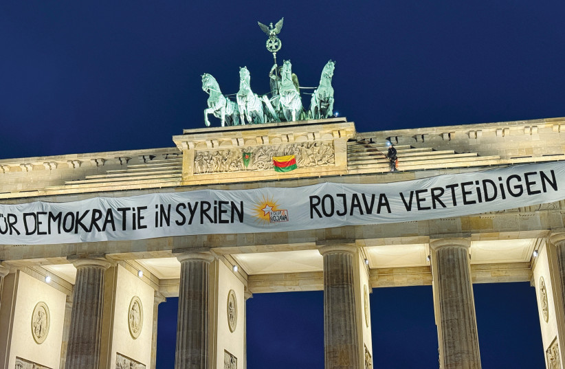 ACTIVISTS PLACE a banner reading ‘For Democracy in Syria, defend Rojava’ on top of Berlin’s Brandenburg Gate, December 16, 2024.
