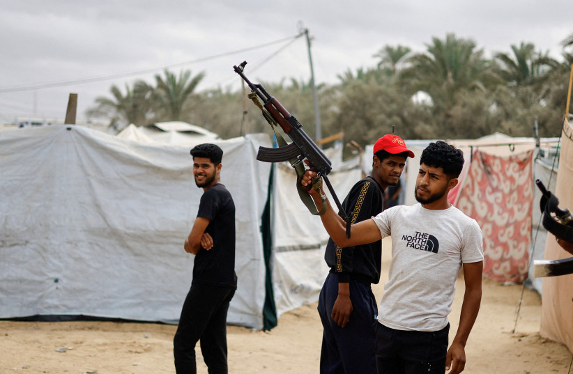 A Palestinian man points a weapon in the air, after US President Donald Trump announced that Israel and Hamas agreed on the first phase of a Gaza ceasefire, in the central Gaza Strip October 9, 2025.