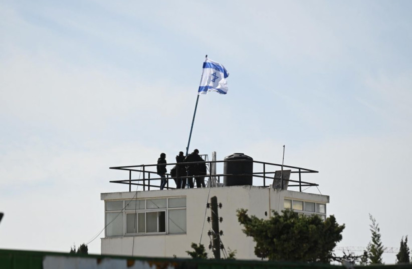 Israeli Police raise a flag over the Jerusalem headquarters of UNRWA on Dec. 8, 2025 after the UN agency failed to pay taxes for several years.