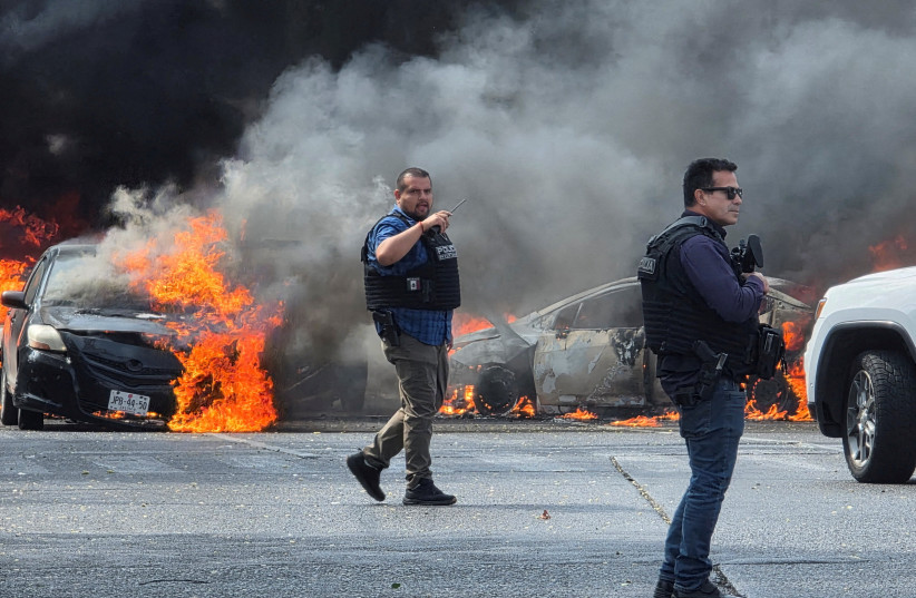 Police officers secure the area where vehicles were set on fire by organized crime members to block a road following a military operation in which a government source said Mexican drug lord Nemesio Oseguera, commonly known as ''El Mencho,'' was killed, in Zapopan, Mexico, February 22, 2026.