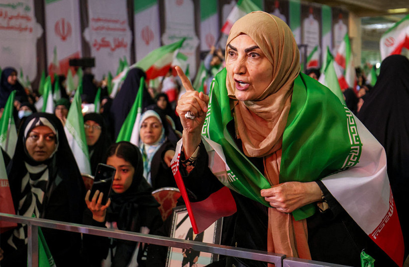 A WOMAN draped in the Iranian flag confronts with protests the government spokesperson (outside frame) attending a memorial ceremony marking the 40th day of mourning for victims of ''terrorism'' killed in previous anti-government protests in Iran, at the Tehran Musalla on February 17, 2026.