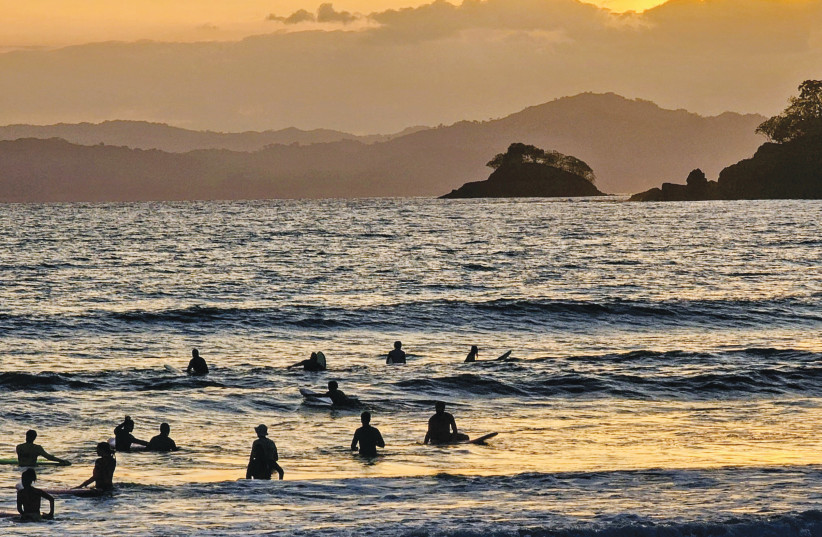 As daylight fades, surfers gather in the water – a daily ritual of rhythm, patience, and shared presence.