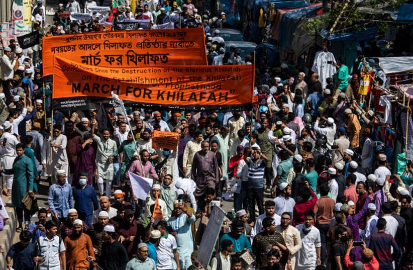 Supporters shout slogans and hold banners of Islamist group Hizbut Tahrir during a march near Baitul Mokarram Mosque.