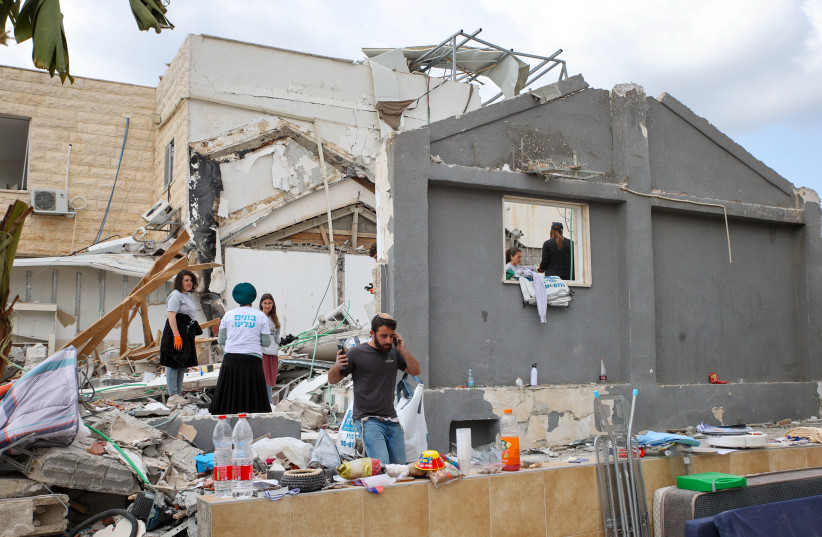 ISRAELIS VOLUNTEER at the site where a missile fired from Iran hit and caused major damage in Beit Shemesh, outside of Jerusalem, March 4, 2026.