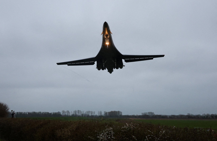 A person looks up as a USAF B1-B bomber prepares to land at RAF Fairford airbase, which also hosts United States Air Force (USAF) personnel, amid the U.S.–Israeli conflict with Iran, in Fairford, Britain, March 6, 2026.