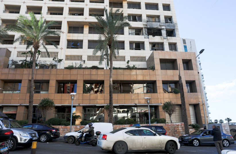 A police car passes by the damaged Ramada Plaza hotel building in the aftermath of an Israeli strike, in central Beirut, Lebanon, March 8, 2026