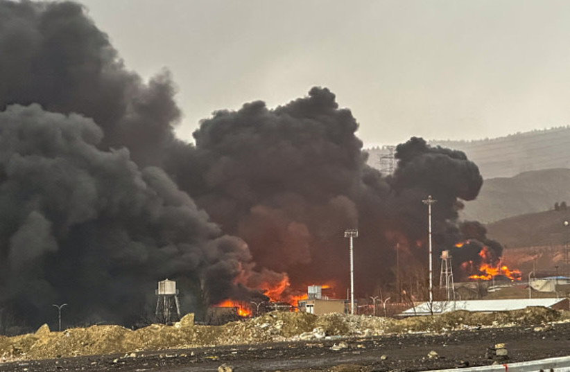 Smoke and flames rise at the site of airstrikes on an oil depot in Tehran on March 8, 2026.