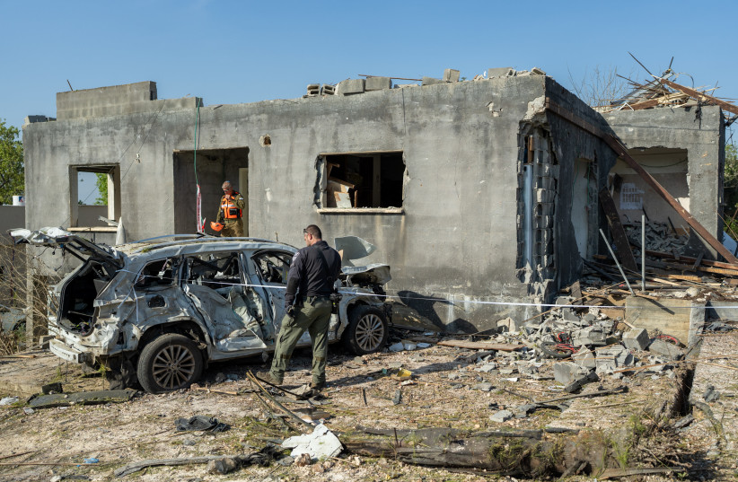 Police and emergency workers stand outside a home destroyed by an Iranian missile strike on March 13, 2026 in Zarzir, Israel.