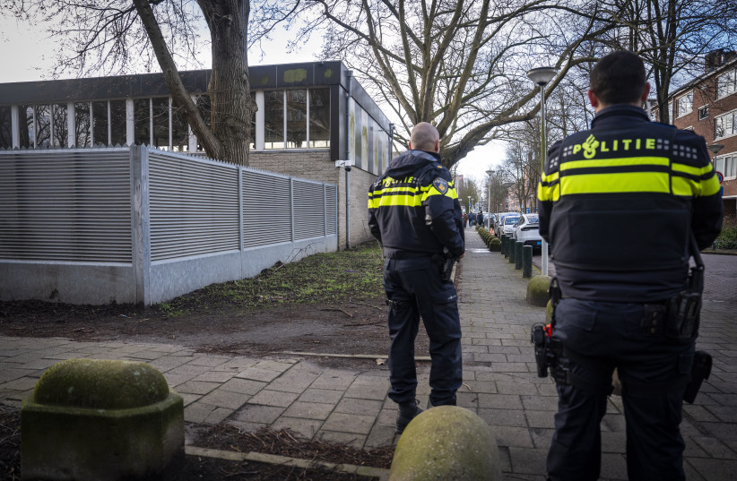 Dutch police officers stand guard near a Jewish school in Amsterdam on March 16, 2026, following its reopening, two days after an attack on the Jewish institution.