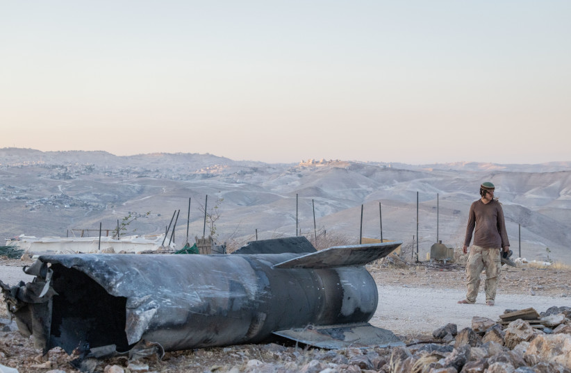 Jewish settlers next to the remains of a ballistic missile fired from Iran in recent war, at a Jewish settlement in the West Bank, June 29, 2025.