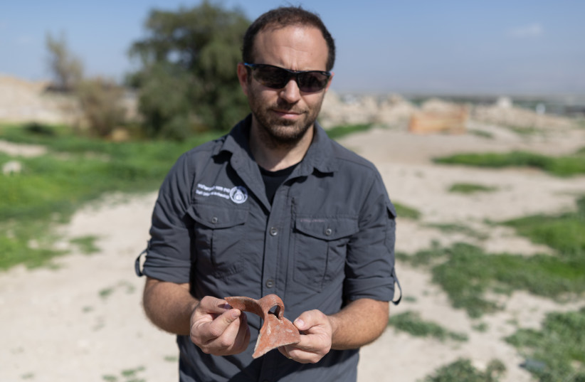Eyal Freiman, archaeologist and deputy head of the Civil Administration's Staff Office for the archaeology department, holds a shard of pottery found at Archelais in the Jordan Valley.