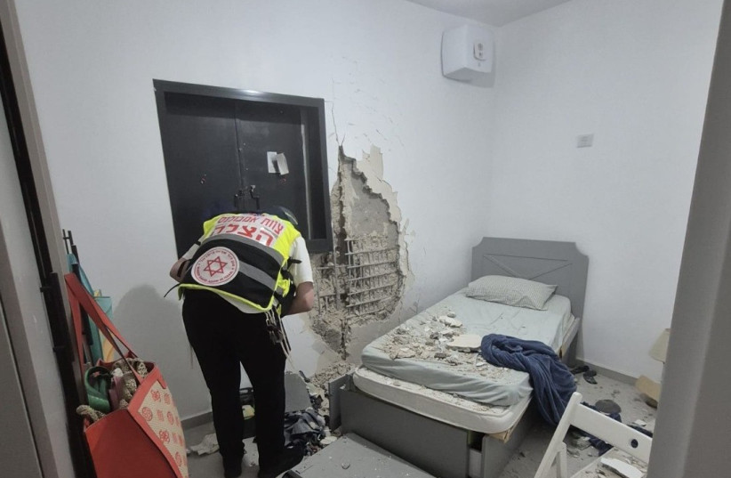 An emergency responder examines the wall of a shelter room in an apartment in Petach Tikva following an Iranian missile barrage on March 24, 2026.