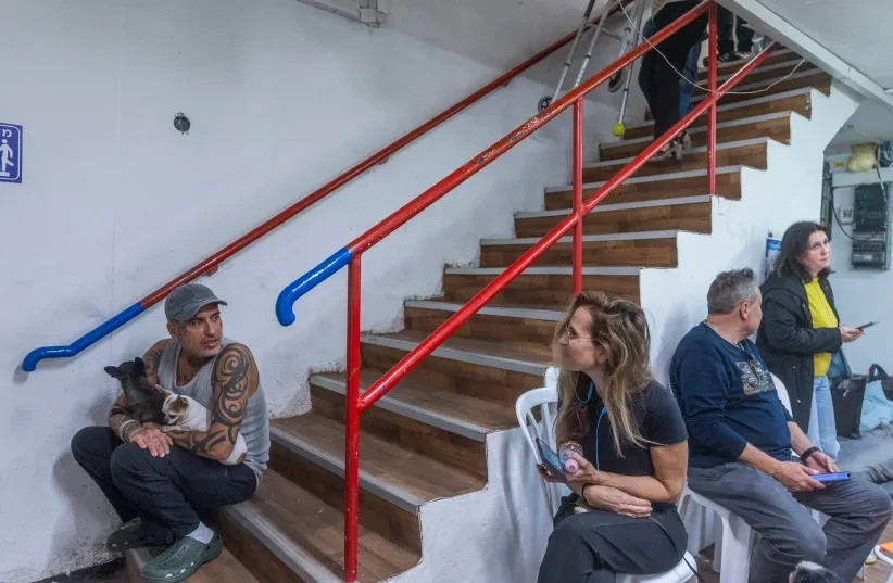La gente se refugia en un búnker para protegerse de los misiles lanzados desde Irán en Holón, el 17 de marzo de 2026. (credit: CHAIM GOLDBERG/FLASH90)