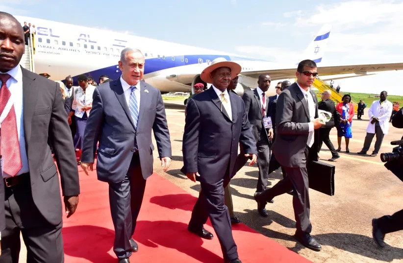 El primer ministro israelí, Benjamin Netanyahu (izquierda), camina junto al presidente de Uganda, Yoweri Museveni (derecha), tras llegar para conmemorar el 40.º aniversario de la Operación Entebbe en el aeropuerto de Entebbe, en Uganda, el 4 de julio de 2016.  (credit: REUTERS/Presidential Press Unit/Handout via REUTERS)