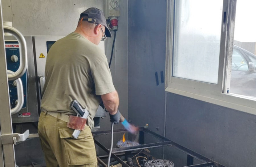 Kashering an army kitchen, blowtorch in hand.