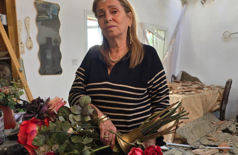 Chava, Daniel Asher’s wife, gathers what remains from the ruins of their home in Beit Shemesh, this month.