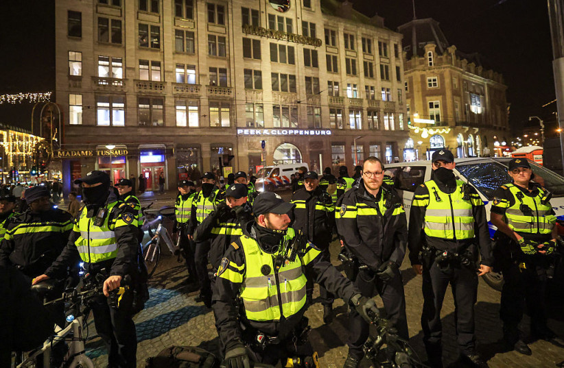 POLICE ARREST individuals who allegedly threw a red substance at an Israeli flag and red smoke bombs in the middle of a demonstration, on December 17, 2025 in Amsterdam, Netherlands.