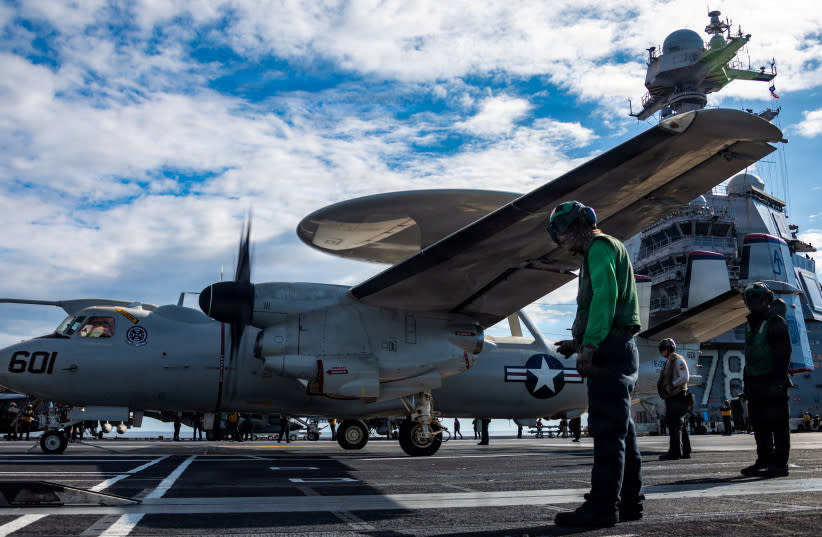 Marineros de la Armada de los Estados Unidos observan cómo un avión E-2D Hawkeye se aproxima a una catapulta de despegue para despegar desde la cubierta de vuelo del portaaviones USS Gerald R. Ford, mientras operan en apoyo de la Operación Epic Fury contra Irán desde una ubicación no revelada (credit: U.S. Navy/Handout via REUTERS)