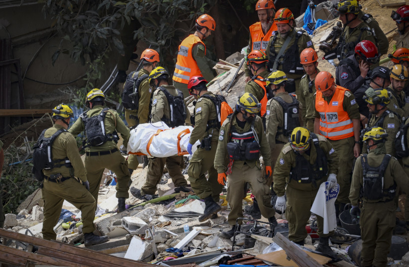Israeli rescue forces recover bodies at the scene where a missile fired from Iran struck a building in Haifa, northern Israel, causing extensive damage, April 6, 2026.