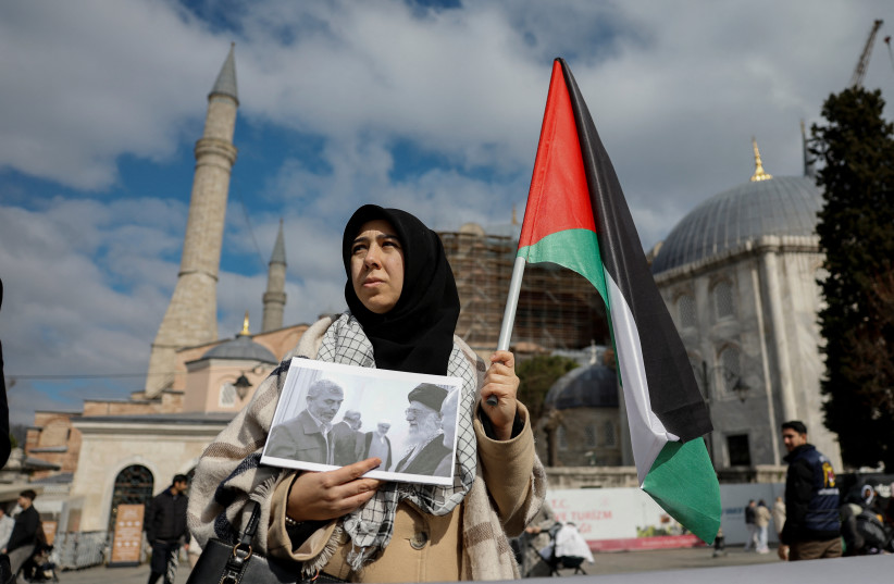A demonstrator holds a Palestinian flag and a picture of late Iran's supreme leader Ayatollah Ali Khamenei with late Hamas leader Yahya Sinwar, during a protest after Khamenei was killed in Israeli and US strikes, in Istanbul, Turkey, March 1, 2026; illustrative.