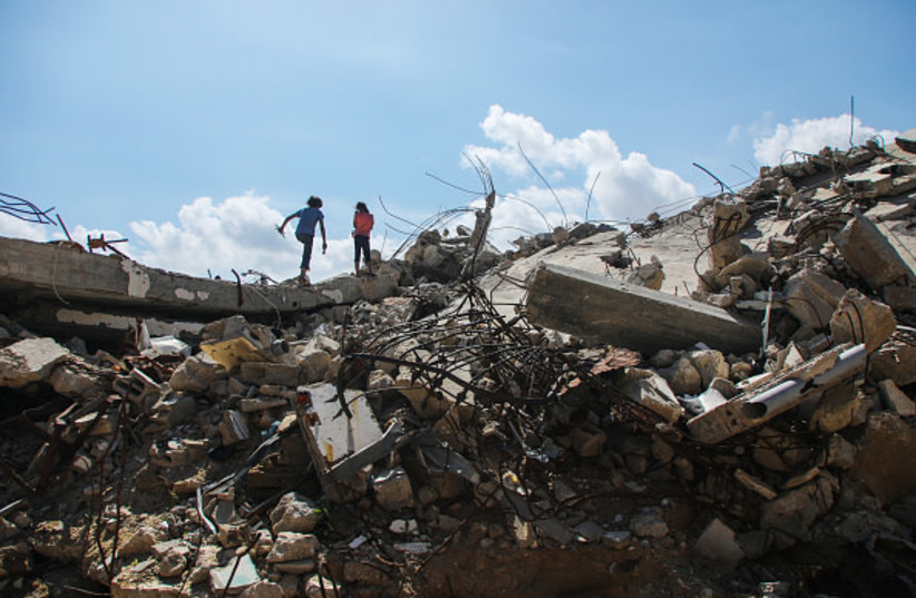 People walk past destroyed homes on April 20, 2026 in Gaza City, Gaza.