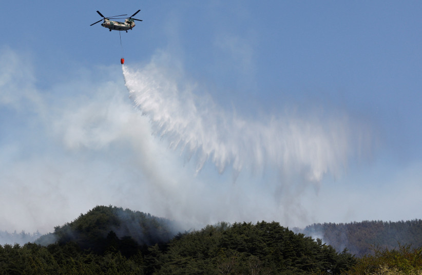 A helicopter conducts firefighting operations, as wildfires continue in Otsuchi, Iwate Prefecture, Japan, April 26, 2026.