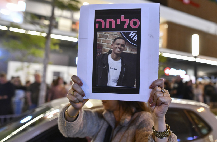 People gather outside a Pizza Hut branch in Petah Tikva, lighting candles and placing flowers in memory of employee Yemanu Binyamin Zalka, who was stabbed and later died of his wounds on the eve of Independence Day, April 25, 2026. (credit: AVSHALOM SASSONI/FLASH90)
